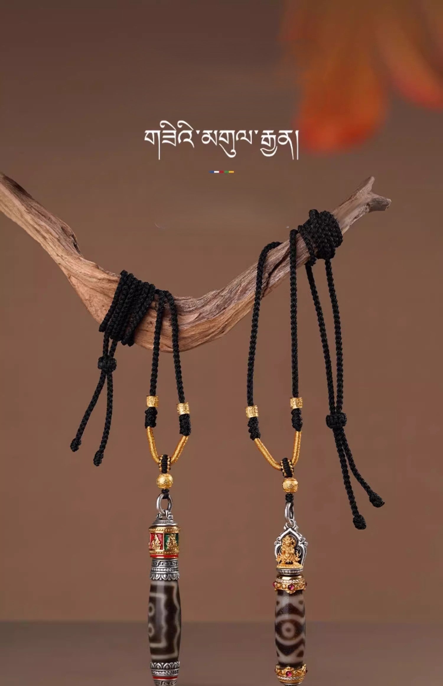 Two Tibetan dzi necklaces hanging from a natural wooden branch