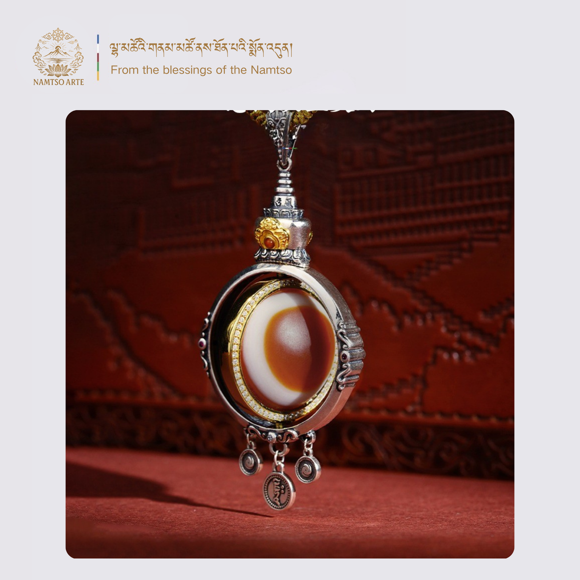Side view of Tibetan dzi eye pendant with intricate silverwork and gemstone inlay
