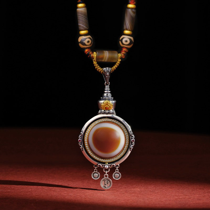 Tibetan handmade Dzi eye pendant necklace in S925 silver and agate on a red background
